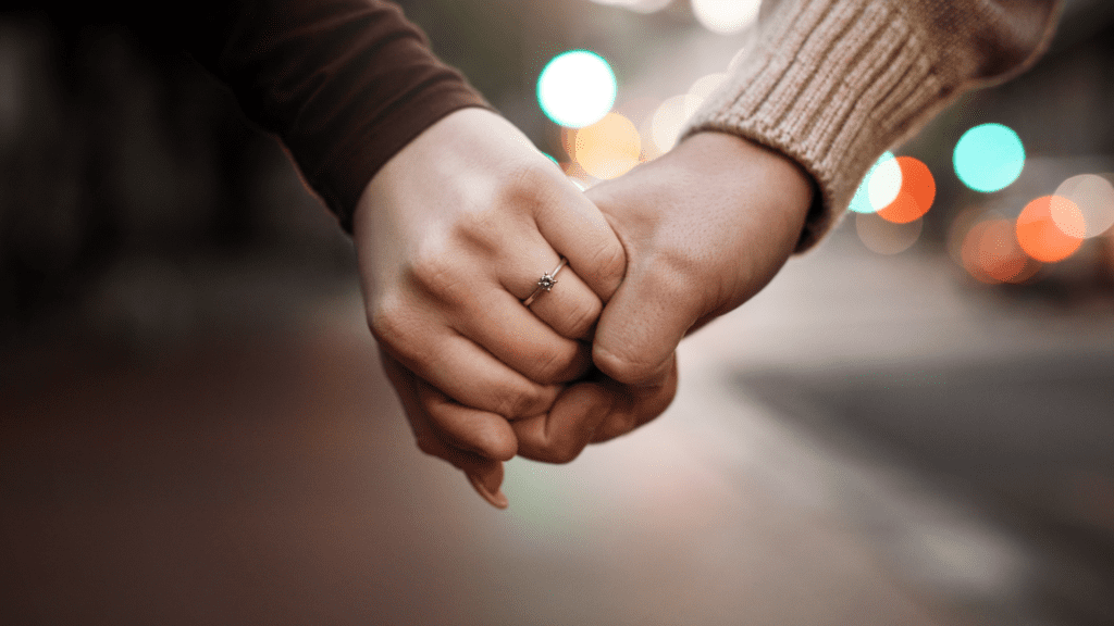 Couple Holding Hands With Engagement Ring