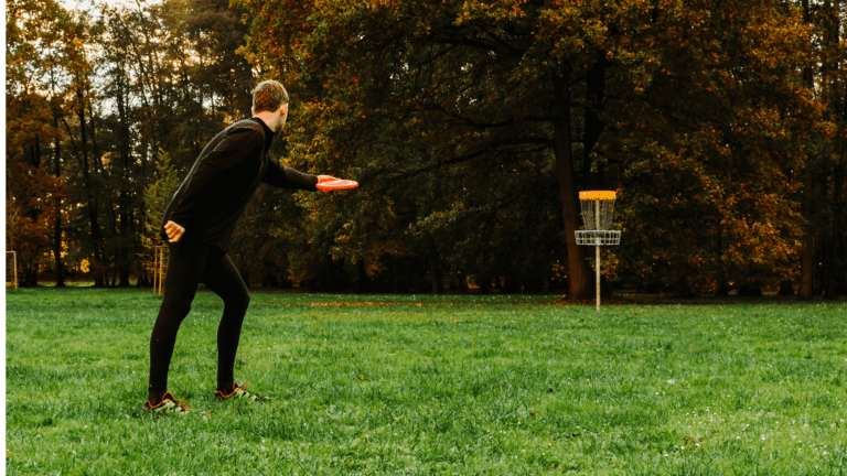 Person Throwing Disc in a Disc Golf Goal