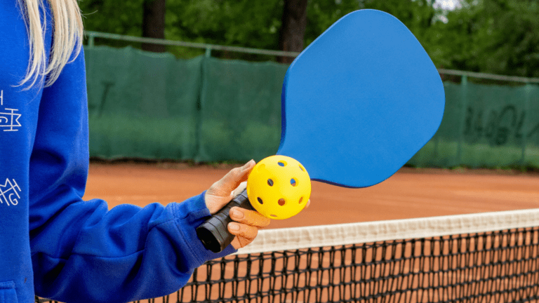 Woman Holding Pickleball Paddle and a Pickleball